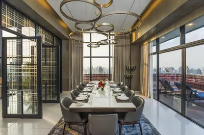a long dining room with a long table and chairs at Emporium Suites by Chatrium in Bangkok