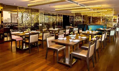 a restaurant with wooden tables and chairs in a room at Emporium Suites by Chatrium in Bangkok