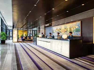 a lobby of a hotel with people sitting at a counter at Emporium Suites by Chatrium in Bangkok