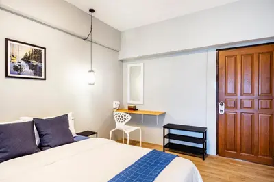 a bedroom with a bed and a desk with a chair at Penyos Service Apartment in Bangkok