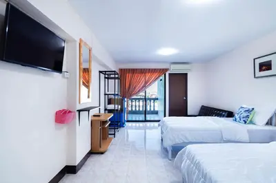 a hotel room with two beds and a flat screen tv at Penyos Suite in Bangkok