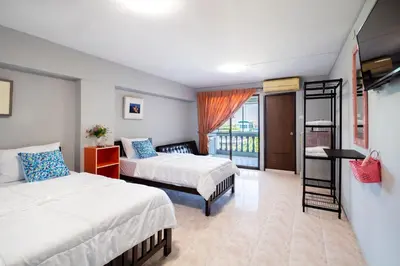a hotel room with two beds and a balcony at Penyos Suite in Bangkok