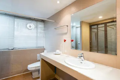 a bathroom with a sink and a toilet and a mirror at The Best Bangkok House in Bangkok