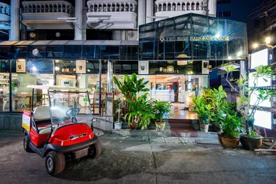 a red scooter parked in front of a building at The Best Bangkok House in Bangkok