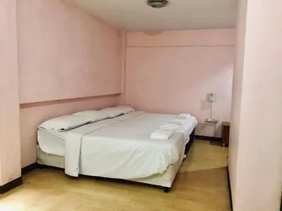 a bedroom with a large white bed in a room at Rajparop PLace in Bangkok