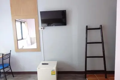 a room with a wall with a tv and a ladder at Rajparop PLace in Bangkok
