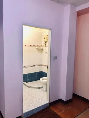 a bathroom with a white toilet and a sink at Rajparop PLace in Bangkok
