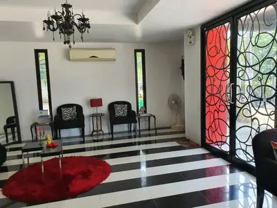 a living room with chairs and a red rug at @Room Apartment in Bangkok