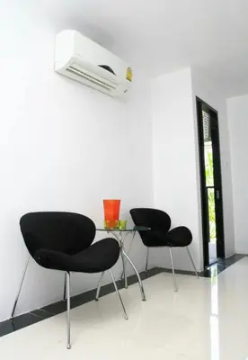two chairs and a table with a heater on a wall at @Room Apartment in Bangkok