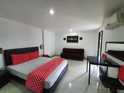 a bedroom with a red and white bed and a couch at @Room Apartment in Bangkok