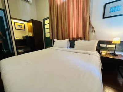 a bedroom with a large white bed and a desk at Chetuphon Gate in Bangkok