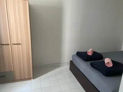a bedroom with a bed with two pillows and a mirror at Dailyroom C3,C4by Anna in Nonthaburi