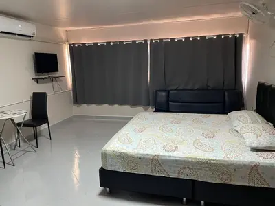 a bedroom with a bed and a table and a television at Dailyroom C3,C4by Anna in Nonthaburi