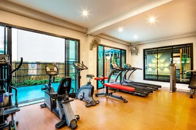 a gym with treadmills and exercise equipment in a room at Penyos Mansion (Long Stay) in Bangkok
