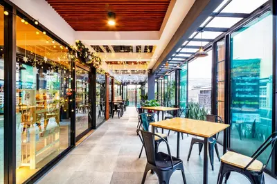 a restaurant with tables and chairs and windows at Penyos Mansion (Long Stay) in Bangkok