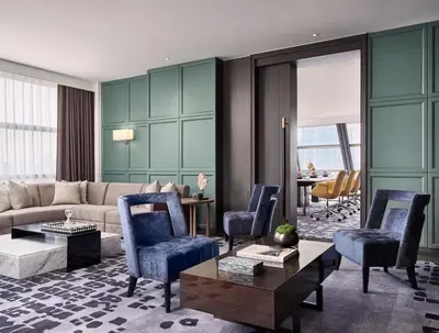 a living room with a couch and chairs and a table at Rosewood Bangkok in Bangkok