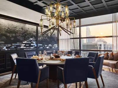 a dining room with a table and chairs and a chandelier at Rosewood Bangkok in Bangkok