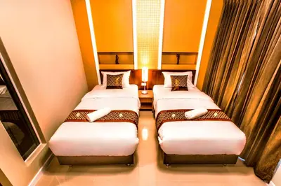 two beds in a small room with at The Aim Sathorn Hotel in Bangkok