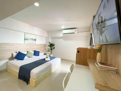 a hotel room with a bed and a tv at 48 Ville Donmuang Airport in Bangkok