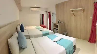 two beds in a small room with red curtains at 48 Ville Donmuang Airport in Bangkok