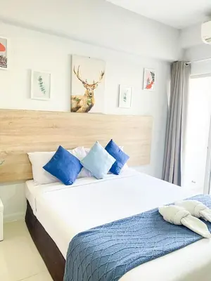 a bedroom with a large bed with blue pillows at 48 Ville Donmuang Airport in Bangkok