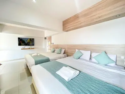 a hotel room with two beds with blue and white pillows at 48 Ville Donmuang Airport in Bangkok