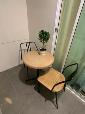 a table and a chair with a potted plant on it at House 116 in Bangkok