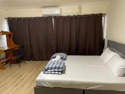 a bedroom with a bed and a desk and a window at Dailyroom by Anna C1-C9 in Nonthaburi