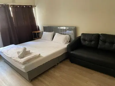 a bed and a couch in a room at Dailyroom by Anna C1-C9 in Nonthaburi
