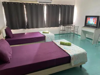 two purple beds in a room with a tv at Dailyroom by Anna C1-C9 in Nonthaburi
