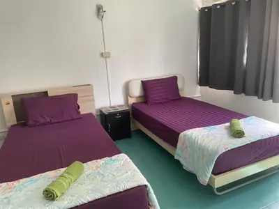 two beds in a room with purple sheets at Dailyroom by Anna C1-C9 in Nonthaburi