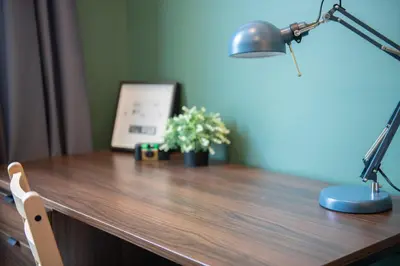 a desk with a lamp and a plant on it at Spacy BKK in Bangkok