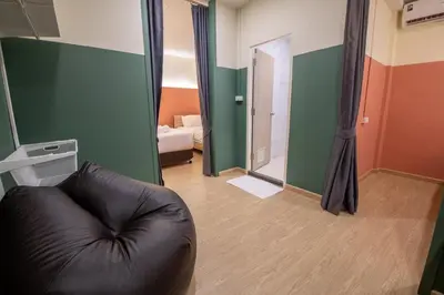 a living room with a leather chair and a mirror at Spacy BKK in Bangkok
