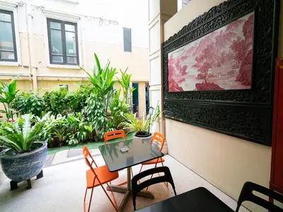 a table and chairs on a balcony with plants at The Ecotel Bangkok in Bangkok