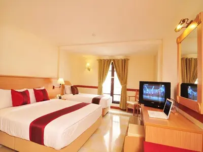 a hotel room with two beds and a television at The Ecotel Bangkok in Bangkok