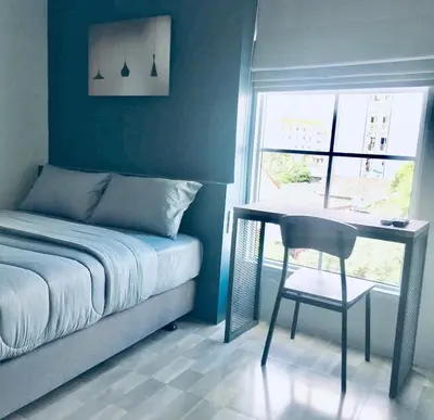 a bedroom with a bed and a desk and a chair at 43 Home in Bangkok Noi