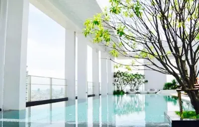 a pool with a tree in the middle of a building at Luxury Apartment near Downtown (Pick-up Service) in Bangkok