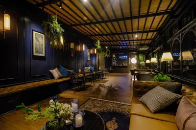 a living room with a couch and tables and chairs at U Sabai Hotel Bangkok in Bangkok