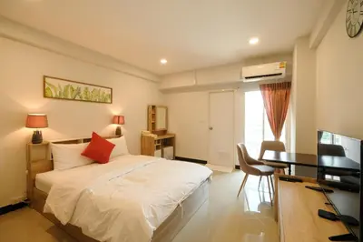 a bedroom with a bed and a desk with a computer at U Sabai Hotel Bangkok in Bangkok