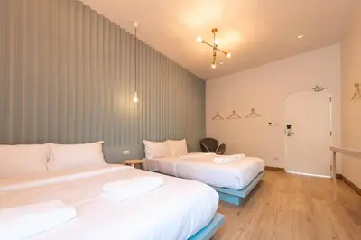 a bedroom with two beds and a hallway with a mirror at Boxpackers Hostel Phranakorn in Bangkok