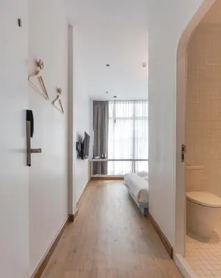 a bathroom with a toilet and a bed in a room at Boxpackers Hostel Phranakorn in Bangkok