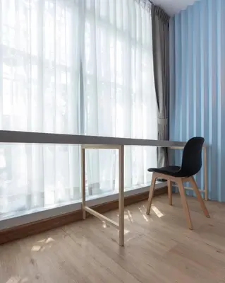 a table and a chair in front of a window at Boxpackers Hostel Phranakorn in Bangkok
