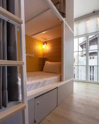 a bunk bed in a room with a window at Boxpackers Hostel Phranakorn in Bangkok