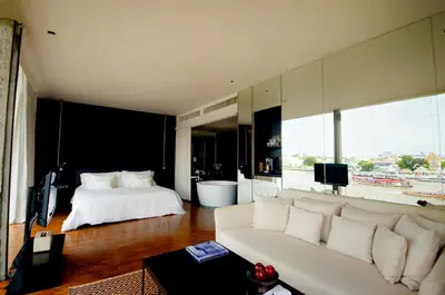 a living room with a white couch and a bed at Sala Rattanakosin Bangkok in Bangkok