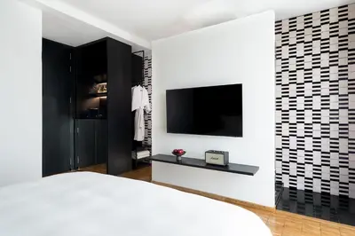 a bedroom with a bed and a tv on a wall at Sala Rattanakosin Bangkok in Bangkok