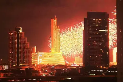 a firework display in a city with tall buildings at The Cosy River in Bangkok