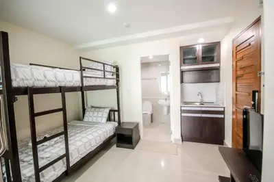 a bedroom with two bunk beds and a bathroom at The Cosy River in Bangkok