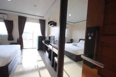a hotel room with two beds and a window at The Cosy River in Bangkok