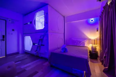 a purple bedroom with a teddy bear sitting on a bed at Infinite Hotel in Bangkok