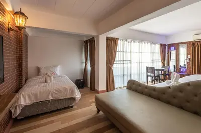 a bedroom with a bed and a couch at Infinite Hotel in Bangkok